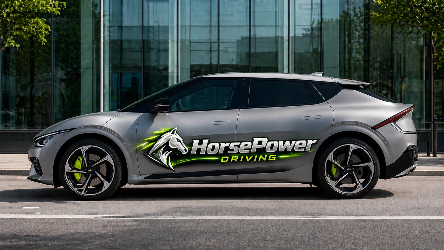Horsepower Driving - Fahrschule - Ein modernes, futuristisches silbernes Crossover-Fahrzeug steht auf Asphalt vor einem eleganten Bürogebäude aus Glas.